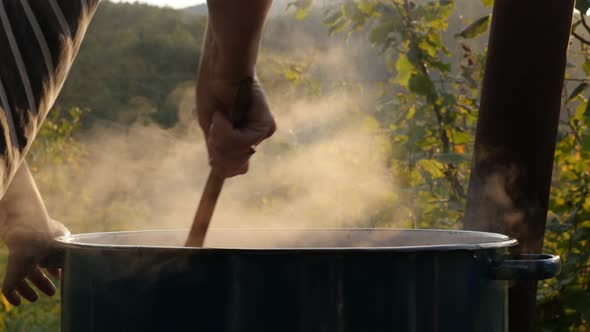 Ajvar preparing outdoor in traditional iron pot 4K footage