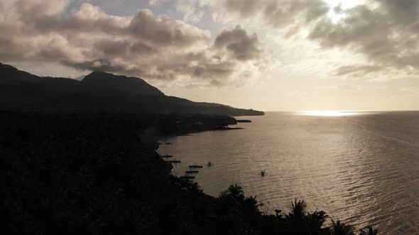 4k drone aerial over an exotic tropical island paradise in the Pacific Ocean at dusk and sun rays sh alt