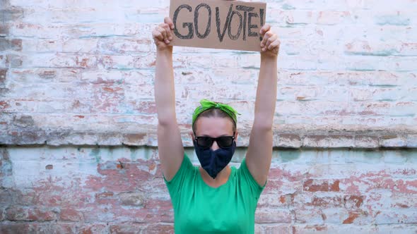 Woman shows cardboard Go Vote  sign Voting balloting polling Political choice elections voice 4K alt