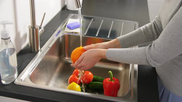 Woman Washing Fruits and Vegetables in Kitchen alt