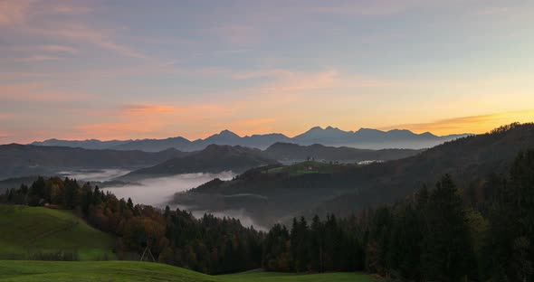 Timelapse View of the Hills, Colorful Forest in the Fog and the Church of Sv Tomaz, Sunrise