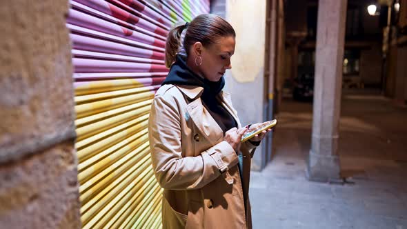 Young Woman with Smartphone on Night City Street alt