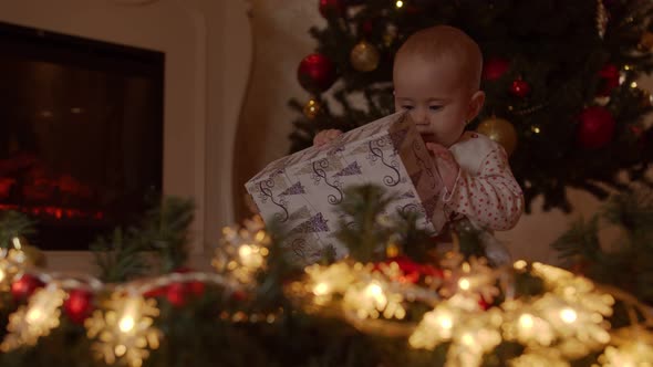 Child with Gift Box By the Christmas Tree