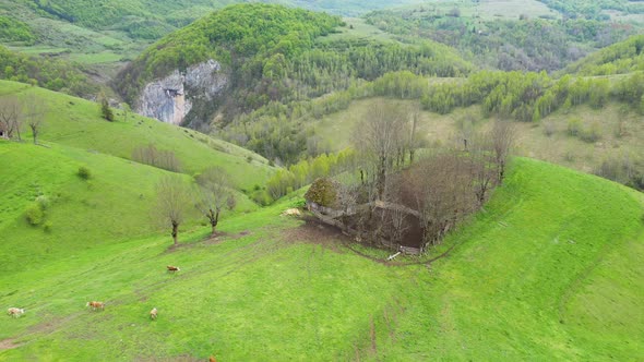 Aerial View of Spring Countryside Landscape with Wooden Houses and Limestone Cliffs alt