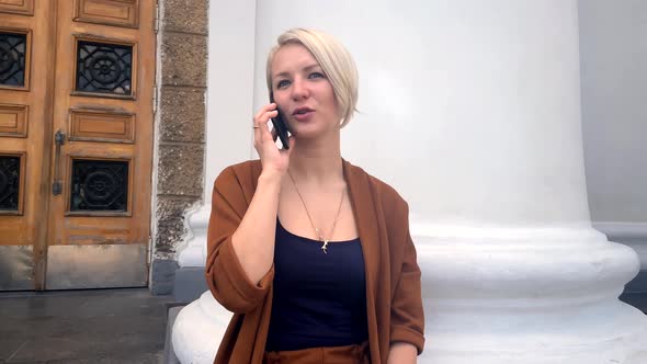 Beautiful Young Woman in a Business Suit Talking on the Phone
