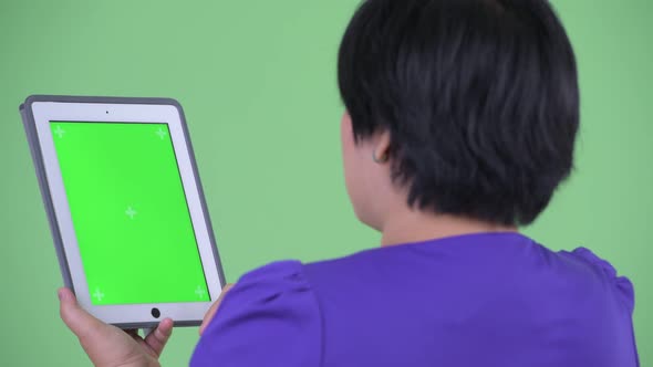 Closeup Rear View of Happy Young Overweight Asian Woman Using Digital Tablet alt