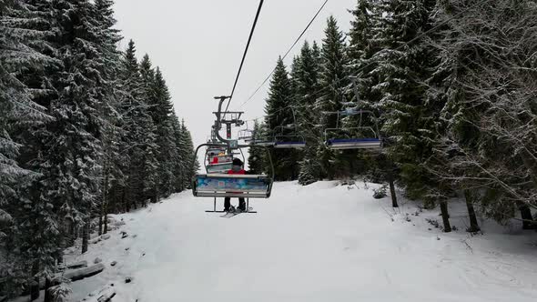 Empty Skilifts Moving On The Ropeway Above Ski Slope In Austrian Alps With People Skiing On The alt