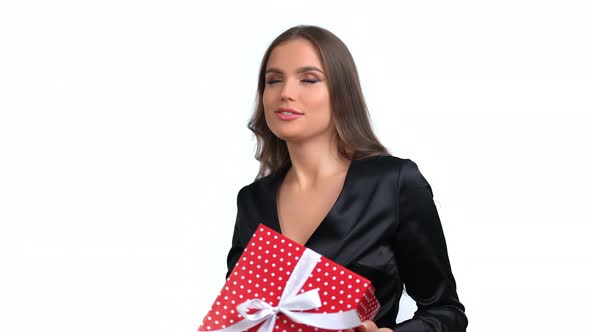 Portrait of Fashion Woman Dancing with Festive Wrapped Red Gift Box Enjoying Holiday Celebrating alt