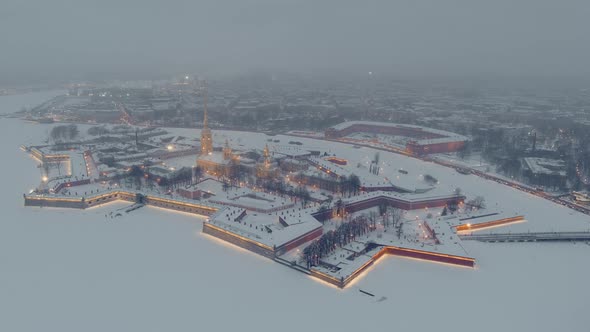 Aerial Footage of the Peter and Paul Fortress in a Snow Storm in a Winter Evening Night Illumination alt
