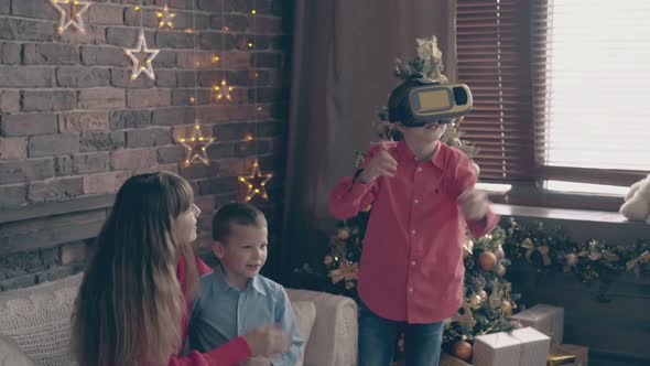 Mother Sits on Couch and Boy Uses Virtual Reality Glasses alt