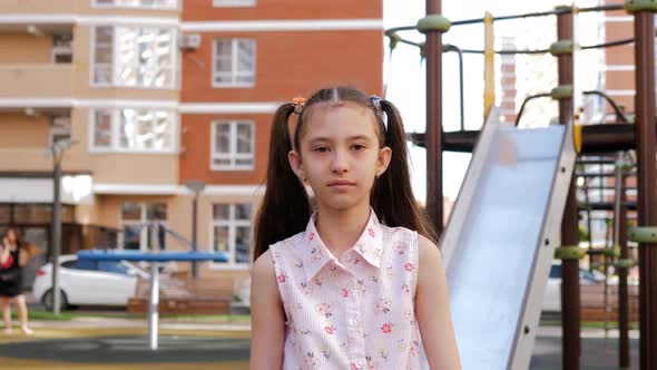 A Preteen Girl is Walking on the Playground