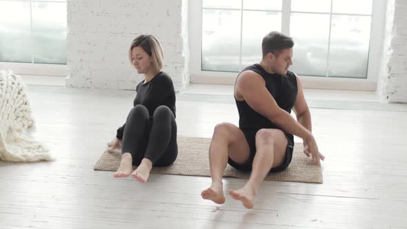 Man and Woman Doing Abs Crunch Exercise and Giving Each Other High Five at Home