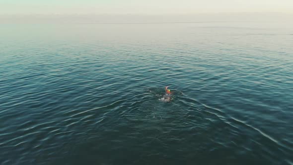 Aerial View of Young Woman Swimming in the Transparent Turquoise Sea Water alt