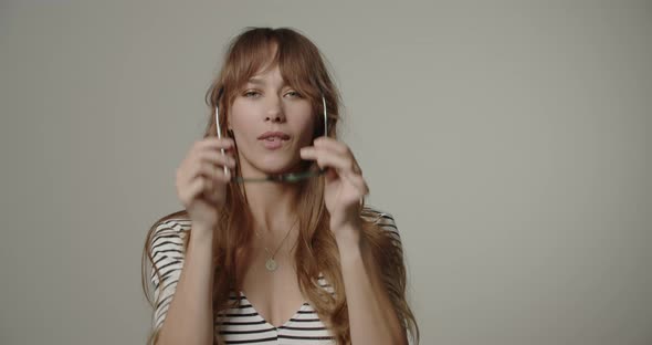 Young Woman With Long Hair Trying On Glasses alt