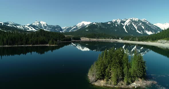Island Of Evergreen Trees Middle Of Mountain Lake Calm Water Reflection Snowy alt
