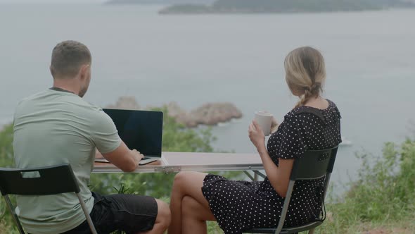 Freelancer Man working at laptop and woman enjoying coffee alt