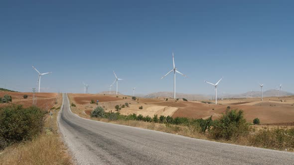 Road Through Windmills Farm for Clean Energy Production in the Mountains alt