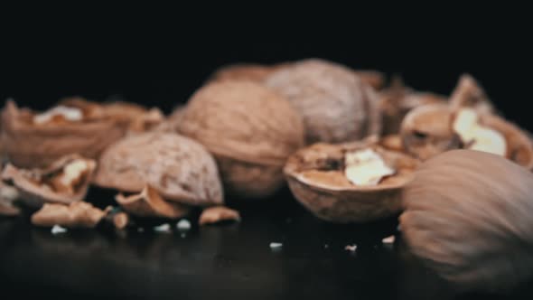 Whole Walnut Rolls in Slow Motion Against a Background of Pile of Nuts in a Loop alt