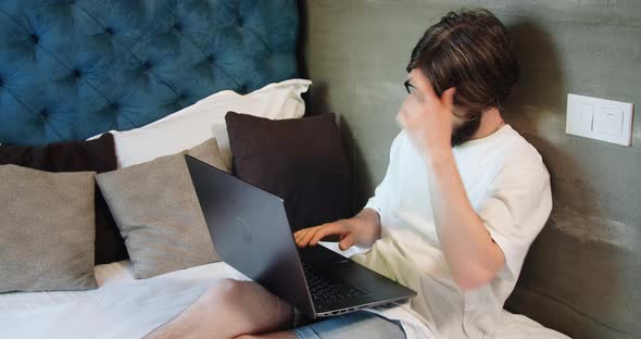 Male Freelancer Working in Bed