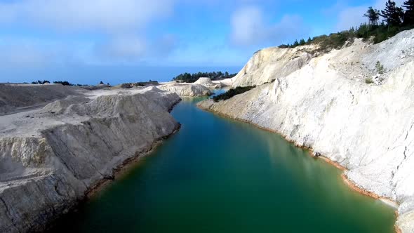 Aerial View Of Green Toxic Lake At Monte Neme Abandoned Mine. Dolly Back Pedestal Down alt