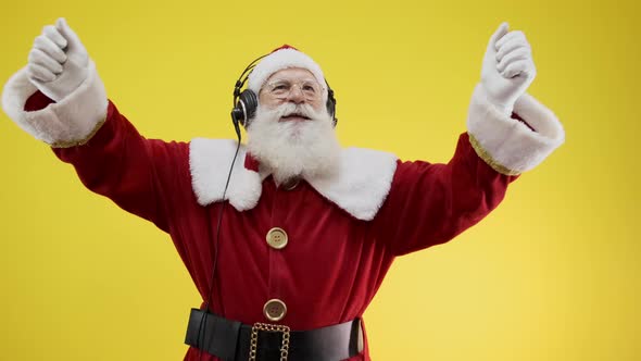 Santa Claus dancing on yellow background. Santa Claus wearing headphones.