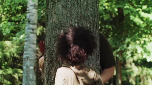 Little Black Girl and Her Smiling Mother Playing in the Green Park  Look Out From Behind a Tree alt