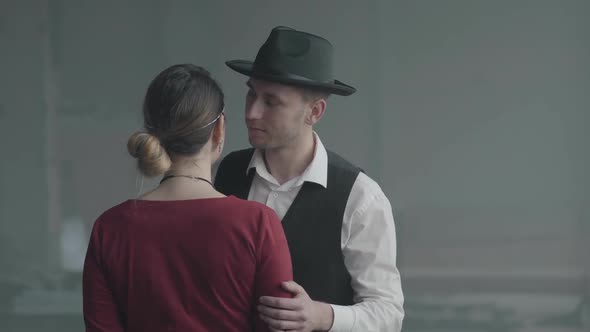 Portrait Handsome Confident Man in a Hat Whispering Joke on the Ear of Elegant Lady Who Standing alt