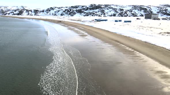 Aerial Top View of Old Wrecked Fishing Ships Drowned at the Sea Shore in Snowy Winter Season alt