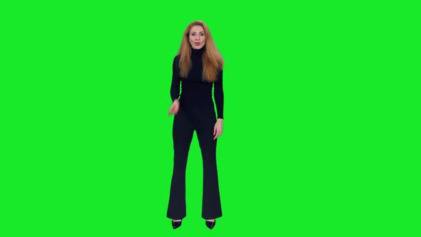Charming Woman in Black Talking and Gesturing While Standing Against Green Screen