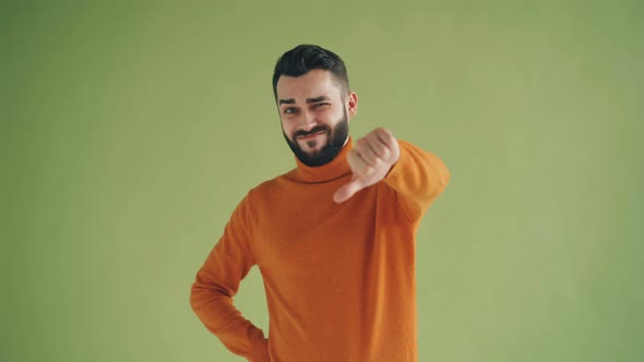 Portrait of Unhappy Hipster Showing Thumbs-down Gesture Looking at Camera alt