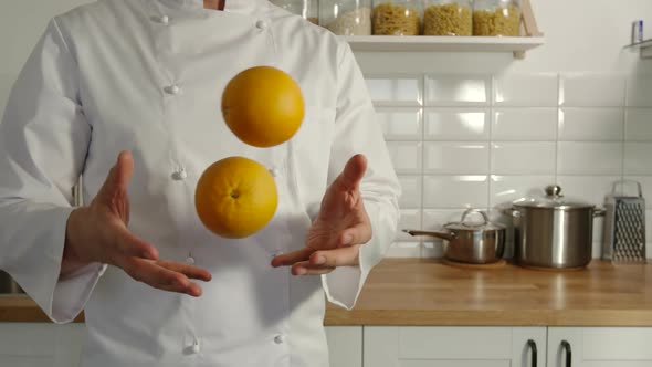 Chief-Cooker Juggles An Oranges In A Kitchen