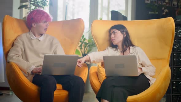 Diverse Multiethnic Couple Sitting on Couch Sofa in Stylish Living Room and Choosing Items Buy alt