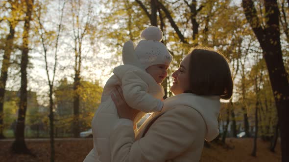 Joyful mom with her child in the autumn park