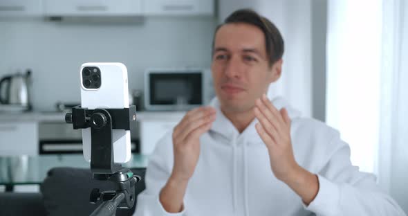 Happy Blogger Man Filming New Vlog Video with Smartphone Camera at Home alt