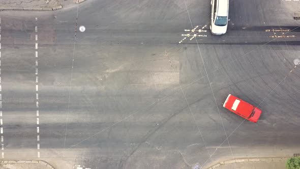 Top down aerial view of city traffic with cars moving on a street at roads intersection. alt