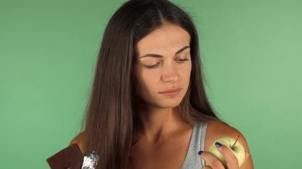 Healthy Woman Choosing Green Apple Over Chocolate Bar 1080p alt