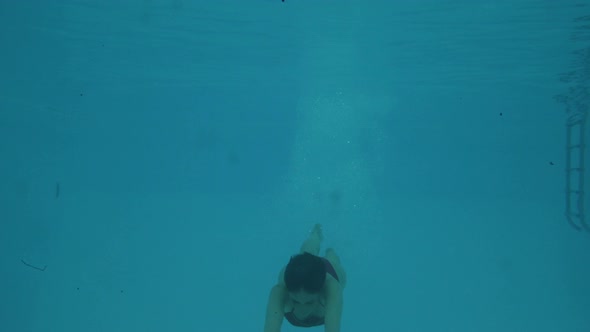 Woman swimming underwater in the pool