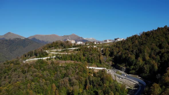 Aerial View of Rosa Khutor Village Among Caucasian Mountain Peaks Against Clear Sky