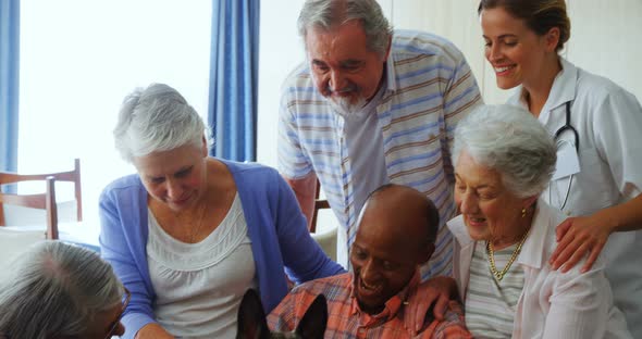 Senior friends petting a dog at retirement home 4k alt