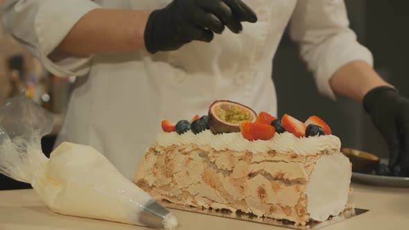 the Pastry Chef Decorates the Meringue Roll with Fruits and Berries