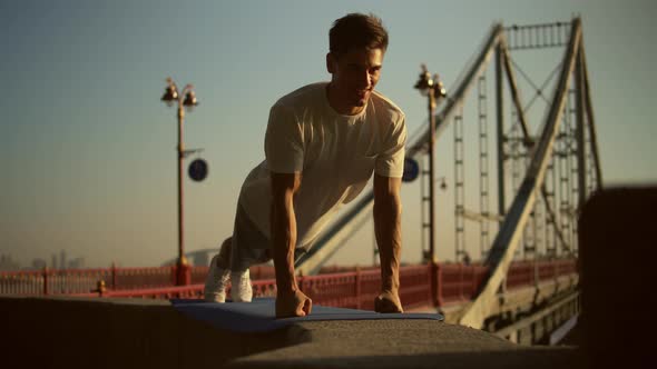 Man Doing Push-ups By the Bridge alt