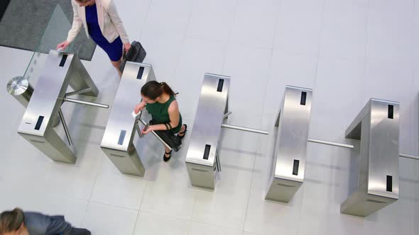 Businesspeople scanning their cards at turnstile gate alt