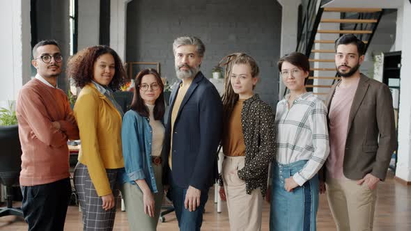 Slow Motion Portrait of Serious Businesspeople Looking at Camera Then Laughing in Modern Office alt