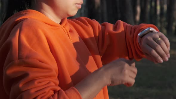 Female runners looking at smart watch heart rate monitor. Athlete running exercising outdoors. alt
