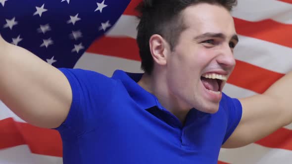 American Young Man Celebrating While Holding the Flag of America in Slow Motion alt