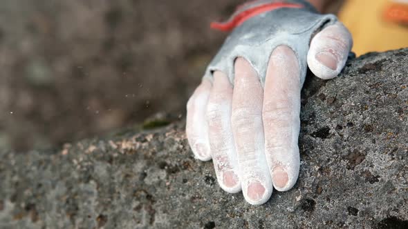 Closeup of a Rock Climber's Hands in Chalk Grabbing a Rock Ledge