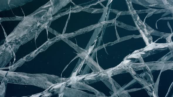 Cracks in Transparent Blue Ice of Frozen Baikal Lake Dolly Motion Close Up View