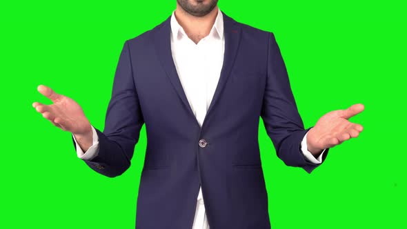 Businessman is using his hands.Green background. alt