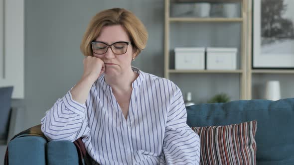 Sad Old Woman Sitting on Sofa alt