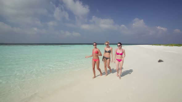 Women in Bikinis on Sandy Beach